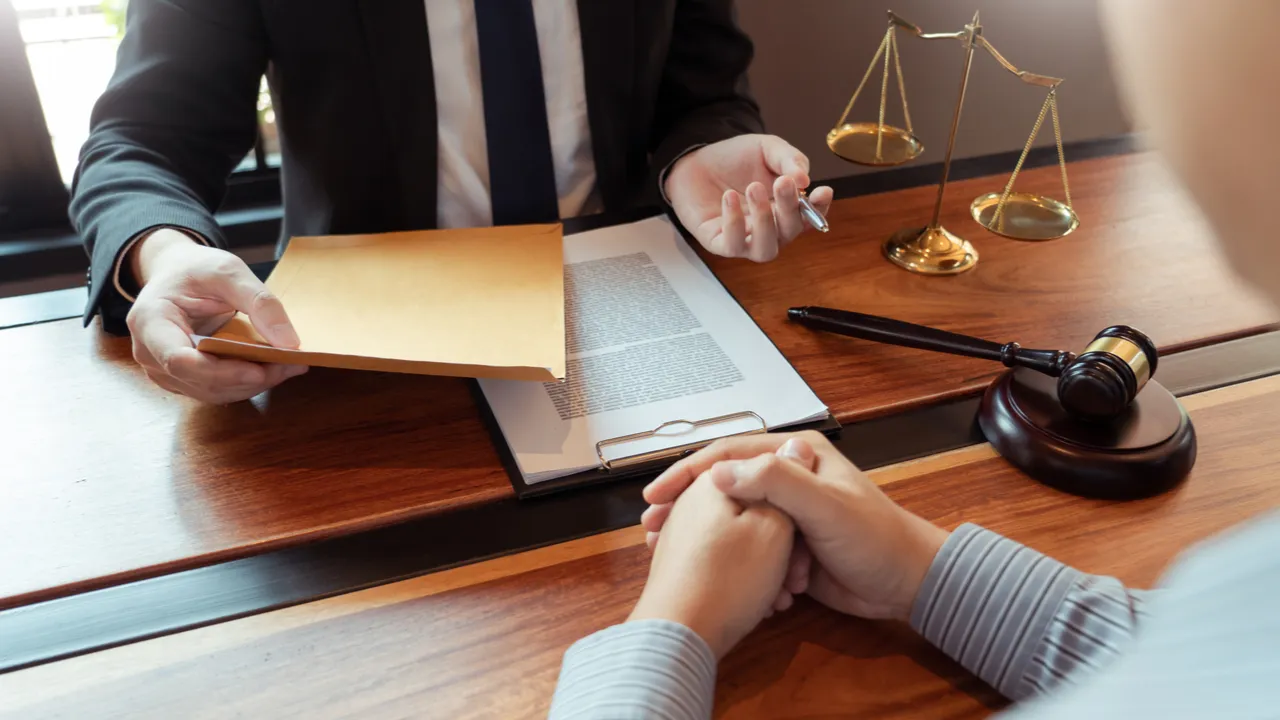 Attorney handing important legal documents to a client during a consultation.