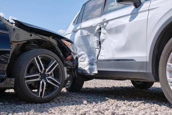 A man and his vehicle pulled over to the side of the road after a car accident.