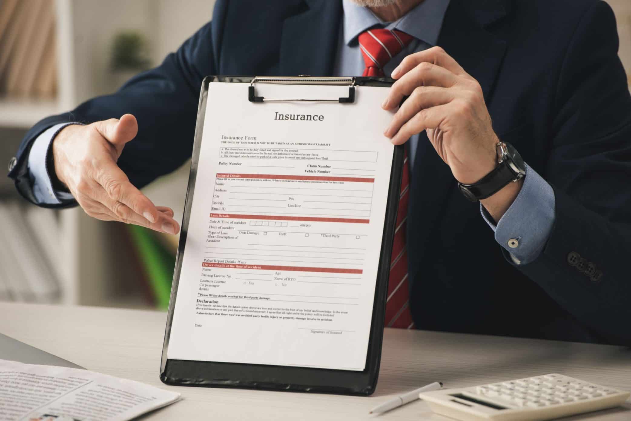 Man reviewing his insurance policy documents intently.